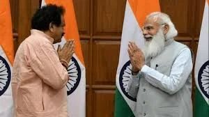 Satyapal Singh Baghel and Prime Minister Narendra Modi exchanging greetings in front of Indian flags